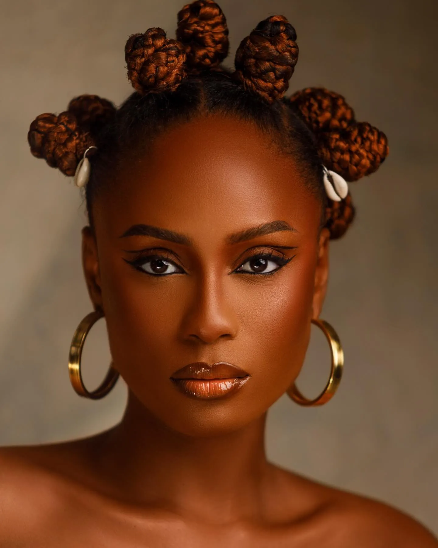 Beauty portrait with bantu knots, cowrie shells and gold hoop earrings