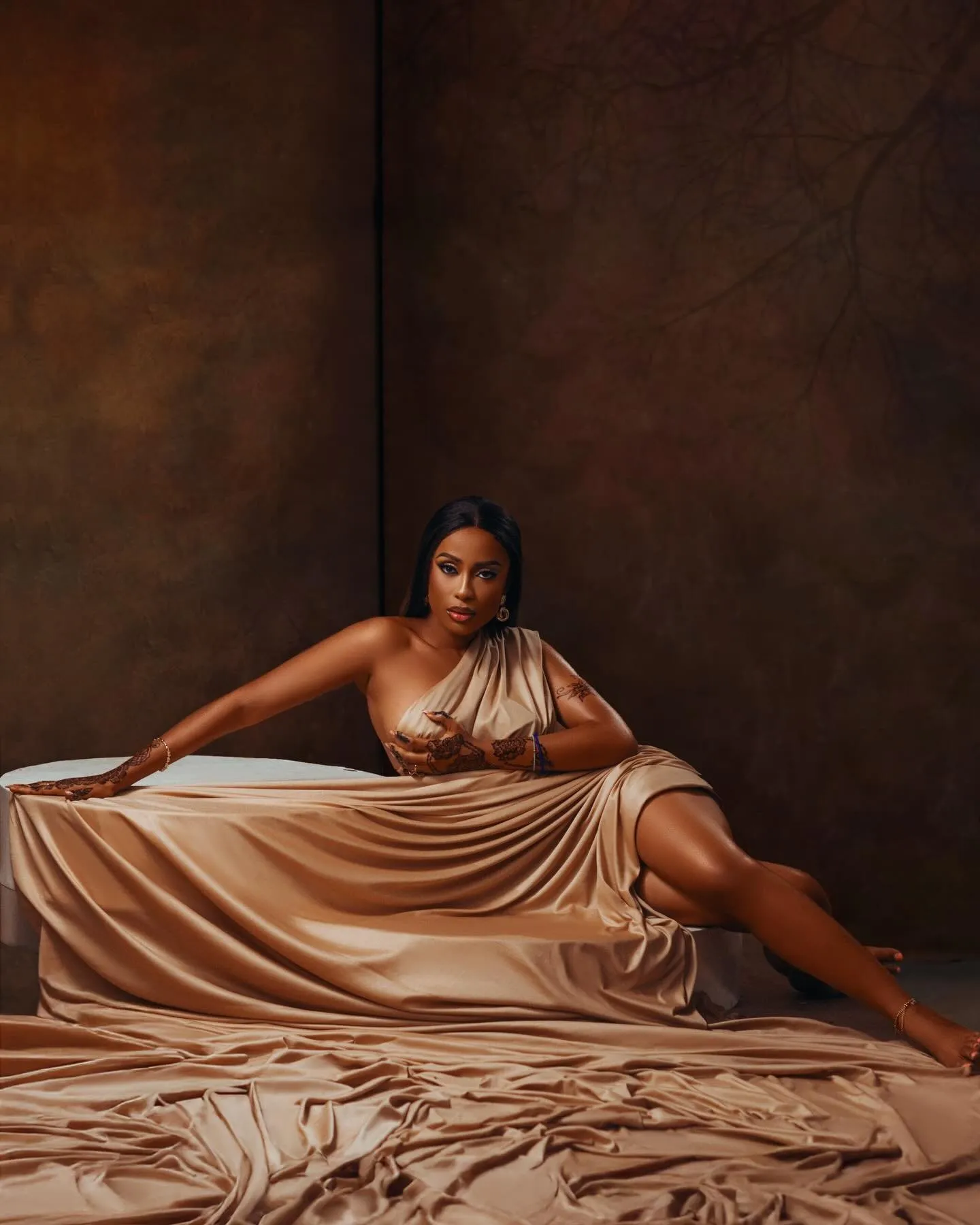 Woman seated low on the draped silk, head tilted back