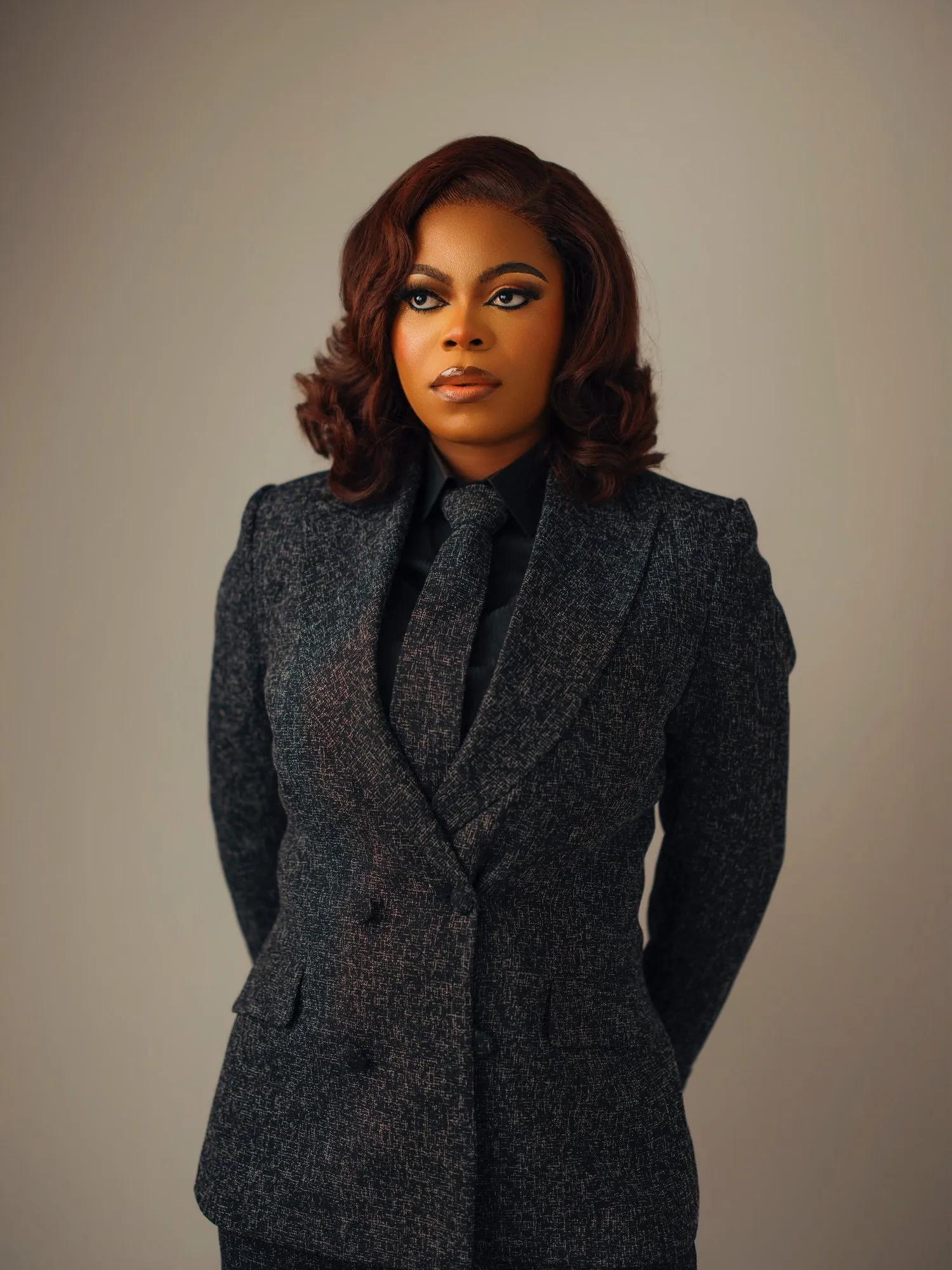 Three-quarter portrait in a tweed suit, looking at the camera