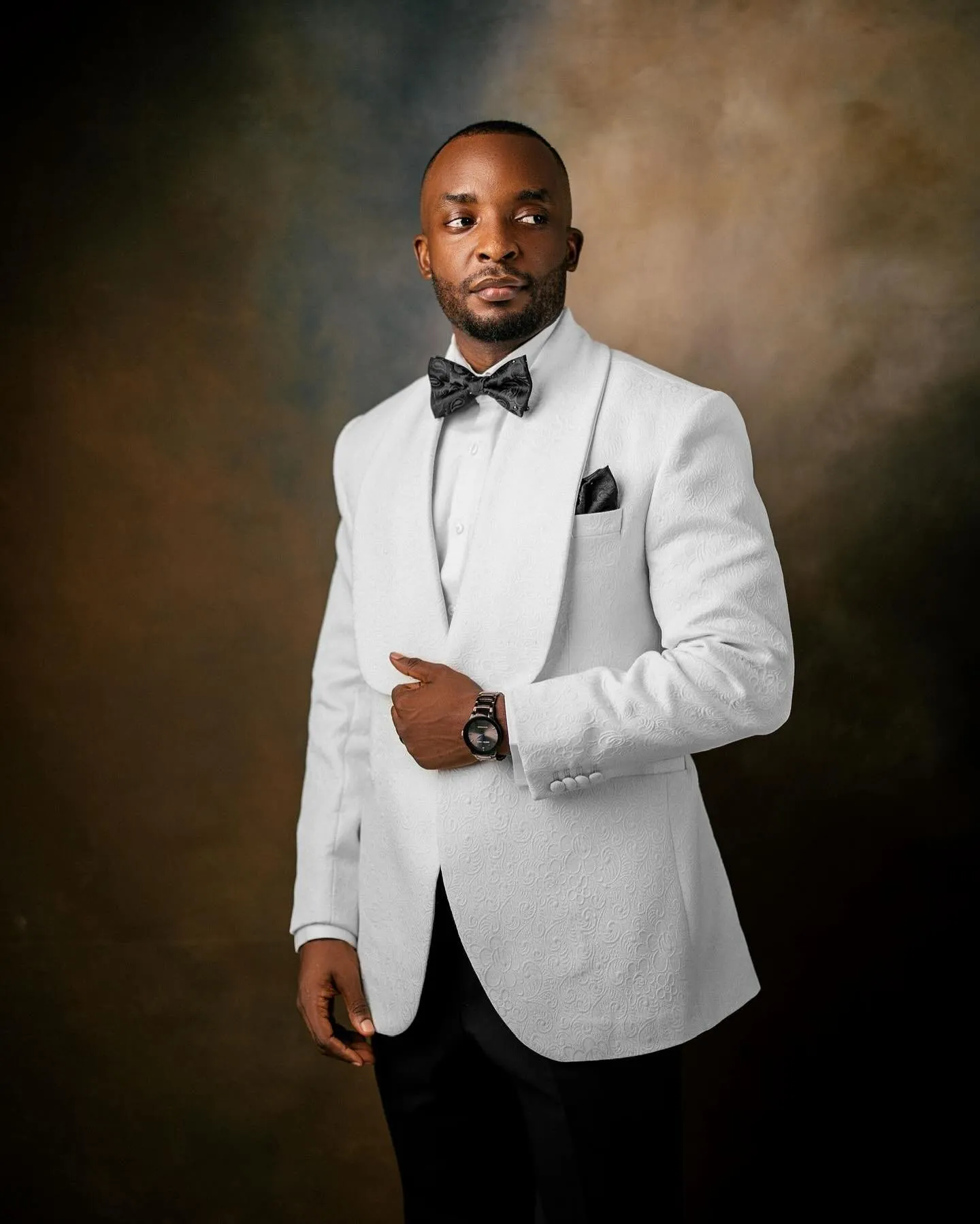Groom in a white tuxedo jacket and bow tie