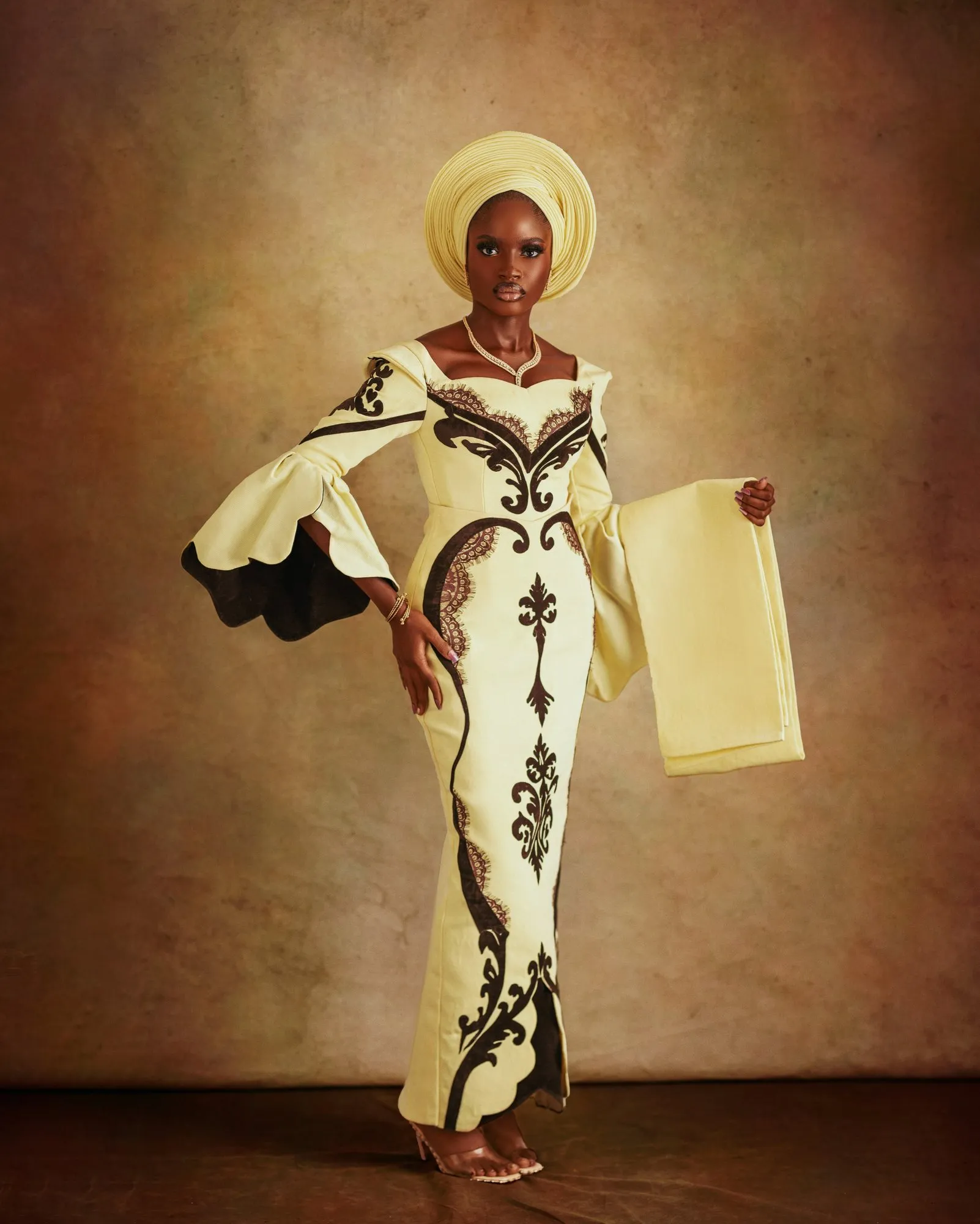 Bride standing with her aso-oke stole draped over one arm