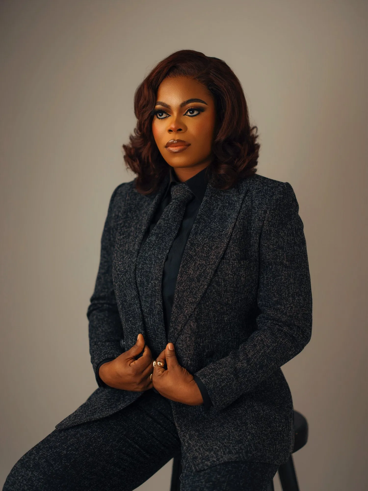 Woman holding the lapels of her tweed jacket