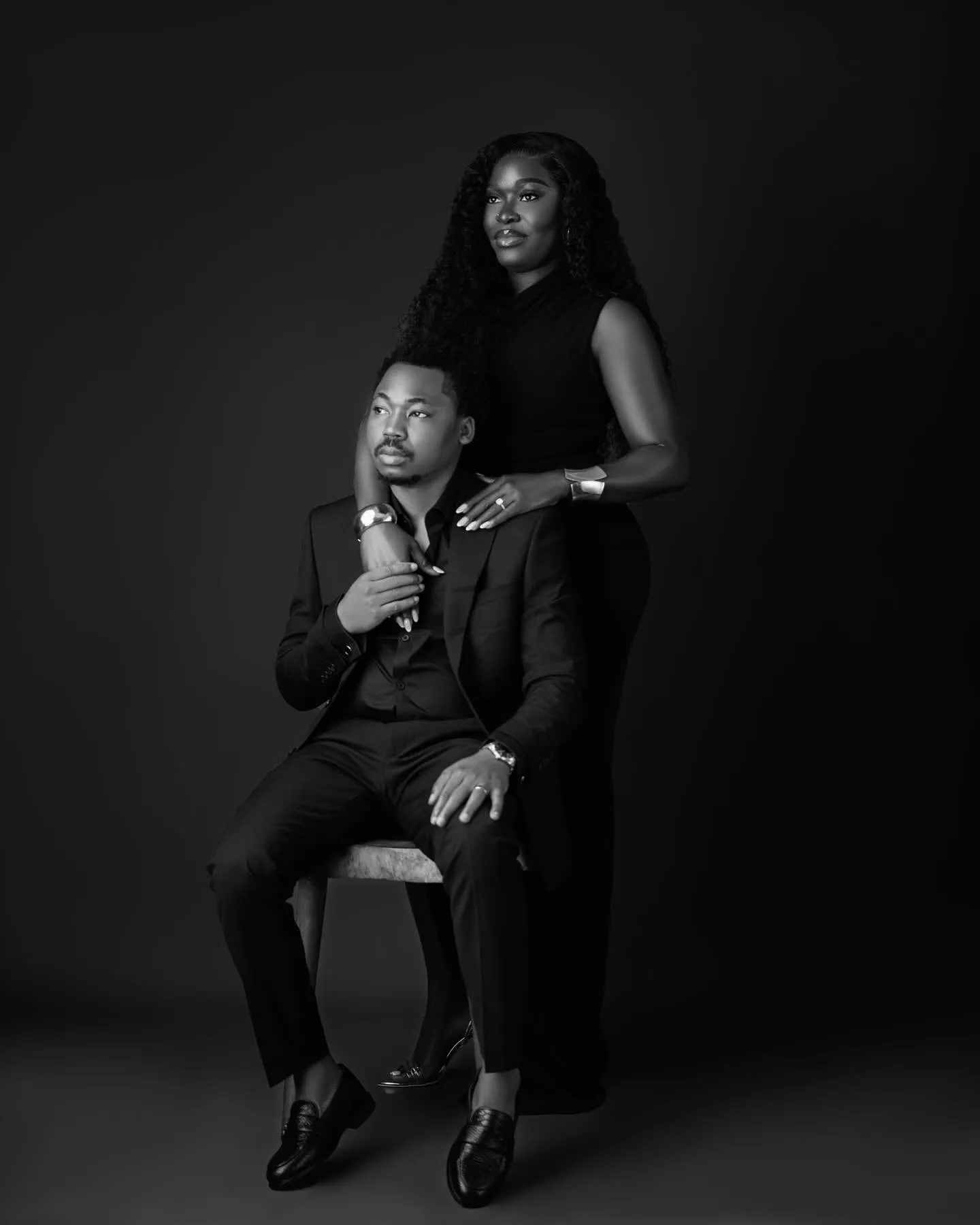 Black-and-white portrait of the couple, he seated, she standing