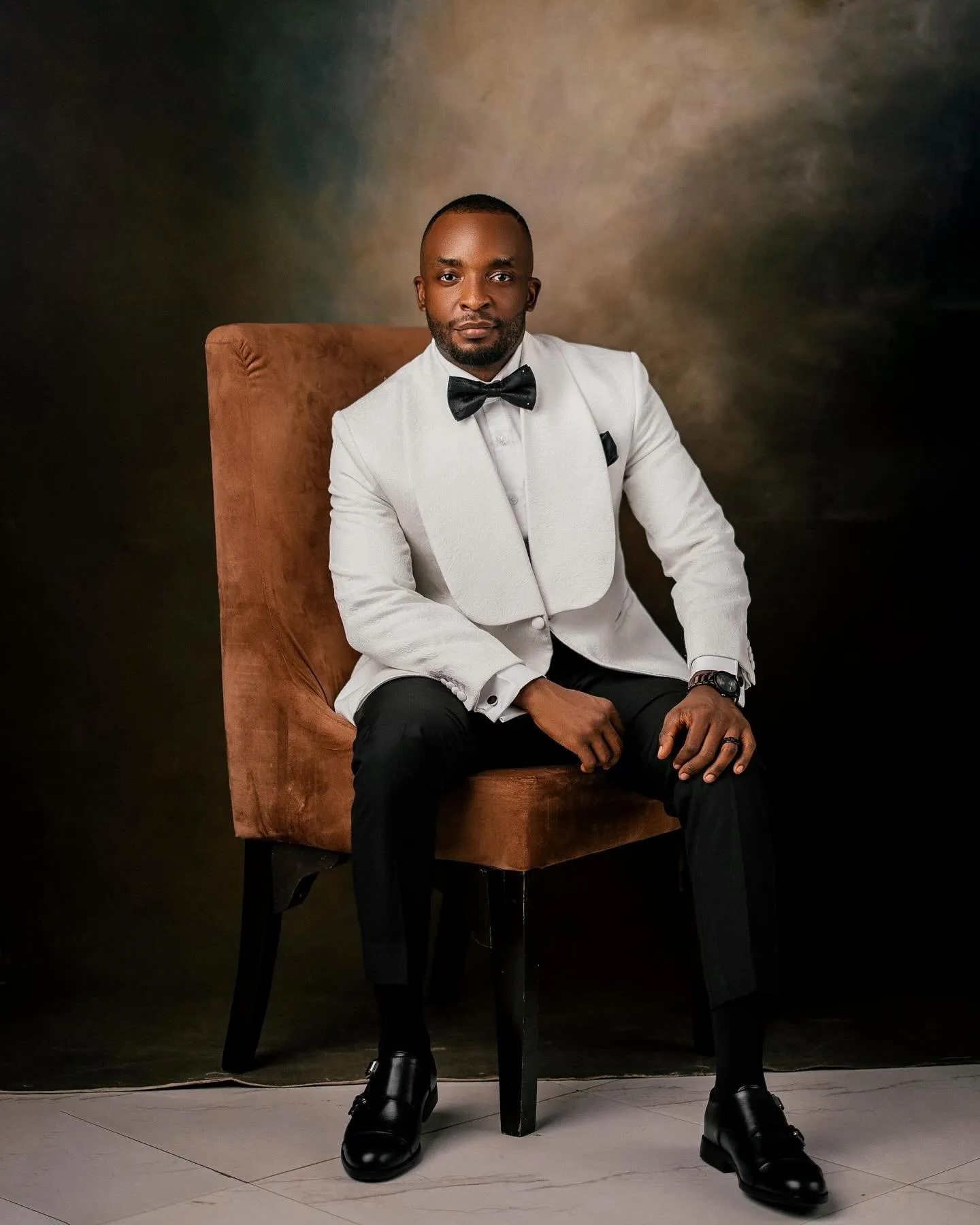 Groom seated in a leather armchair