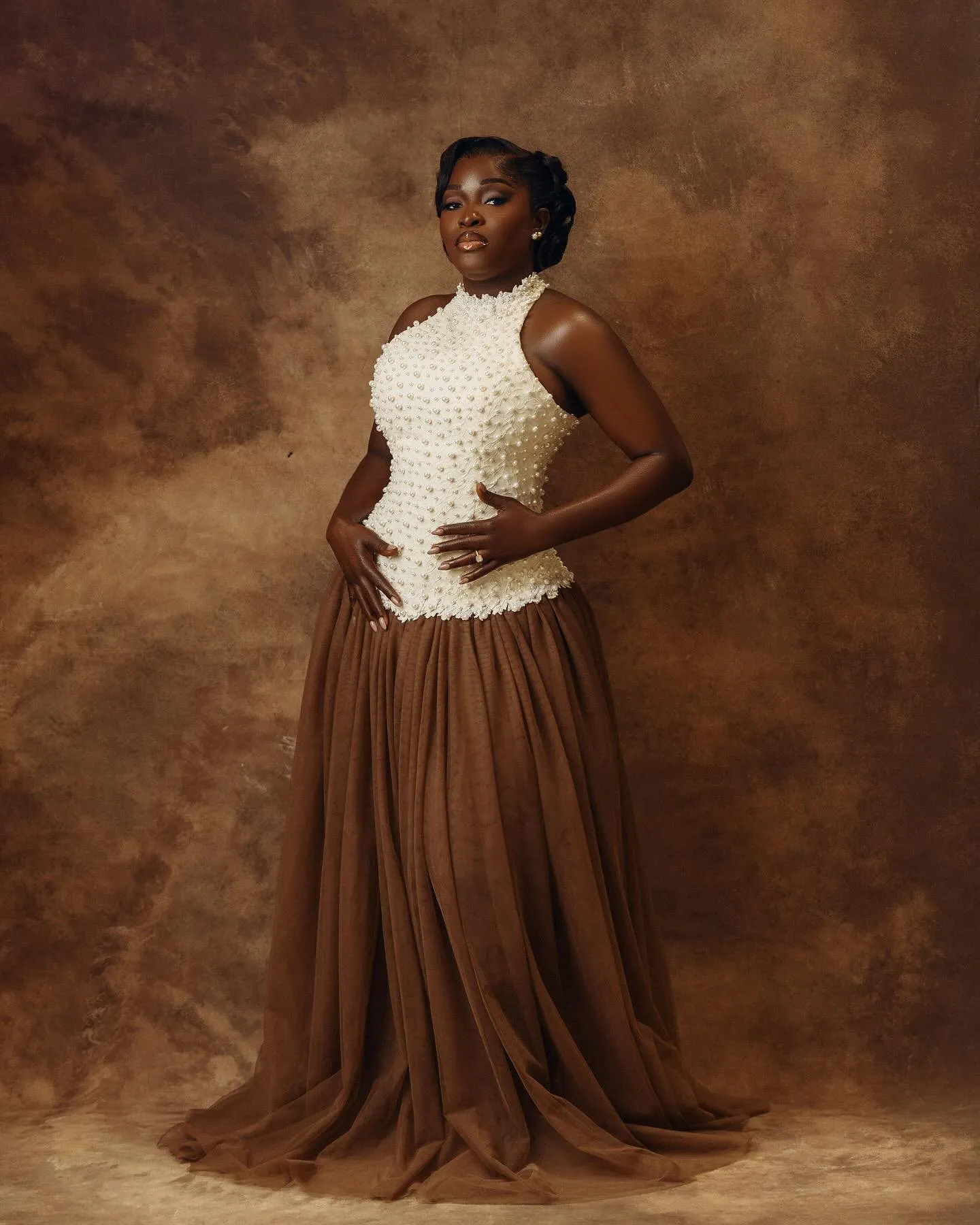 Bride standing in the pearl top and a brown skirt