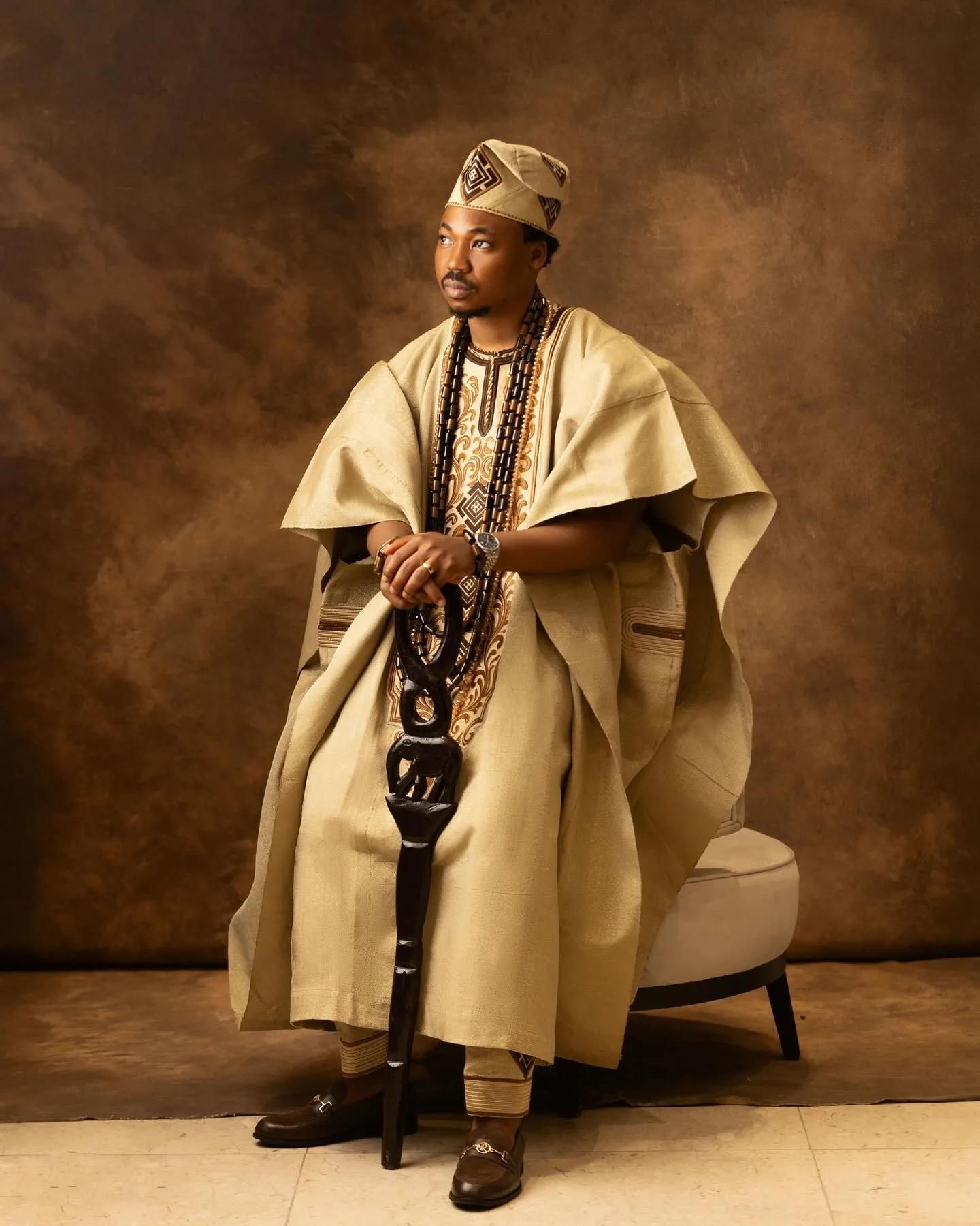 Groom seated, agbada spread around him