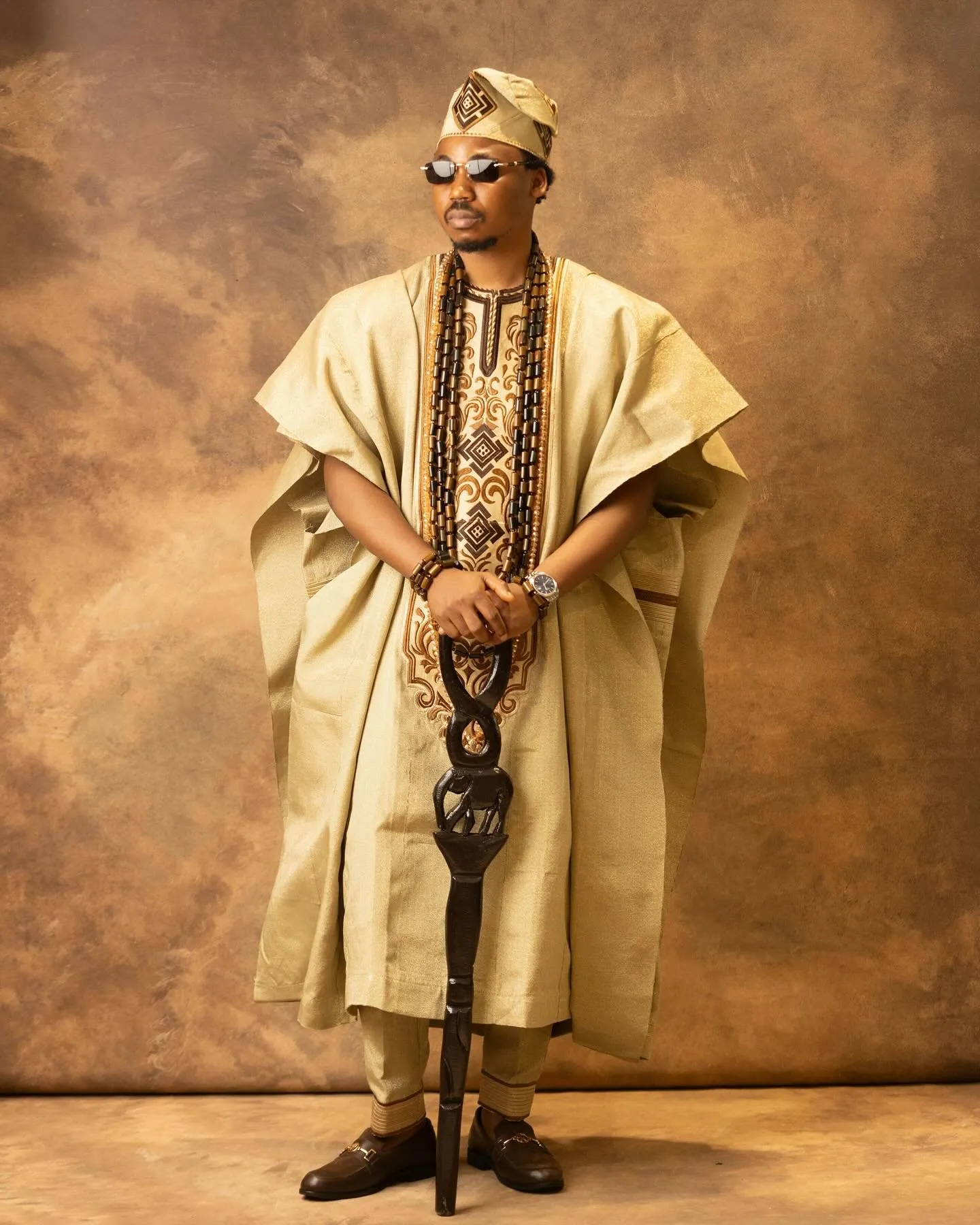 Groom standing full length in gold agbada