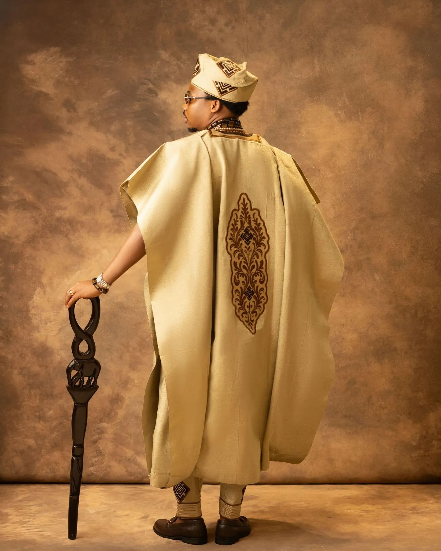 Groom from behind, resting on his cane